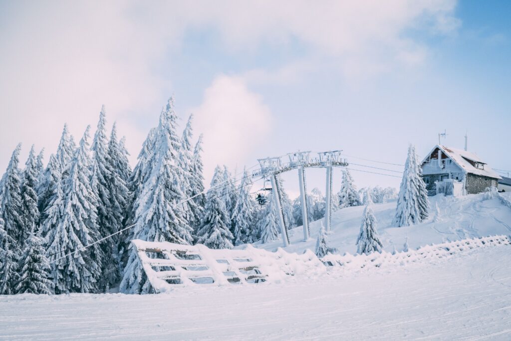 Snow-covered ski resort in Predeal, Romania with frosty trees and clear blue sky.